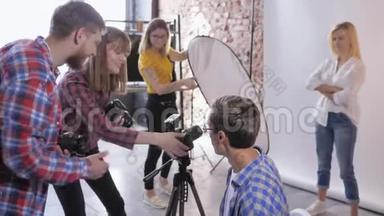 摄影工作室，摄影组在专业摄影工作室讨论数码相机的设置
